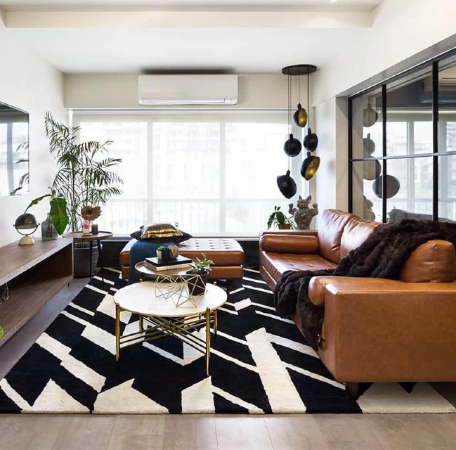 3. Tan Leather Sofa with Graphic Black Rug and Gold Round Tables