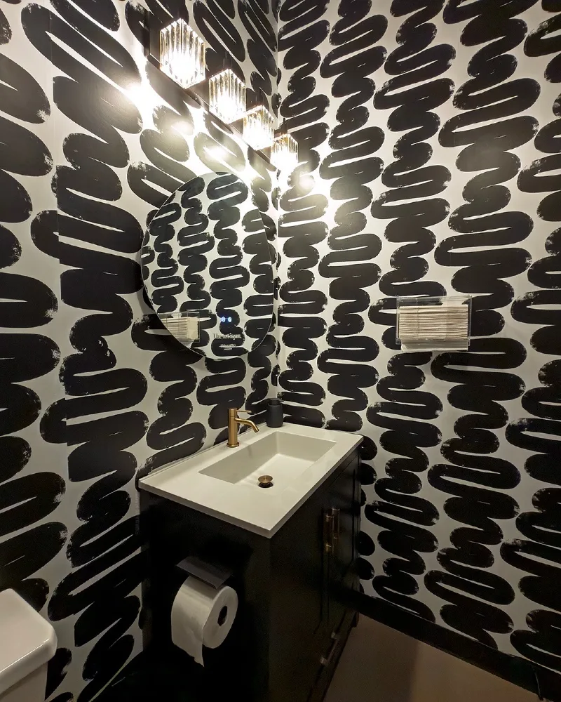 4. Bold Brushstroke Monochrome Wallpaper with Modern Black Vanity and Brass Accents