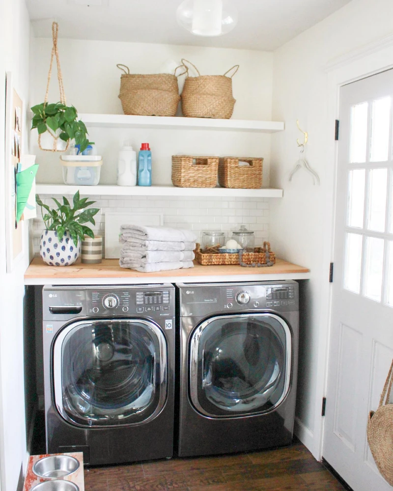 4. Bright Laundry Closet with White Shelves, Woven Baskets, and Butcher Block Counter