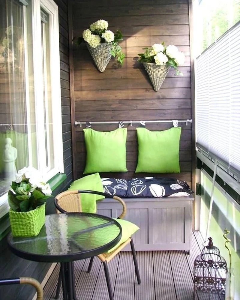 4. Dark Wood Balcony Bench with Lime Pillows, Wicker Wall Baskets, and Glass Bistro Table