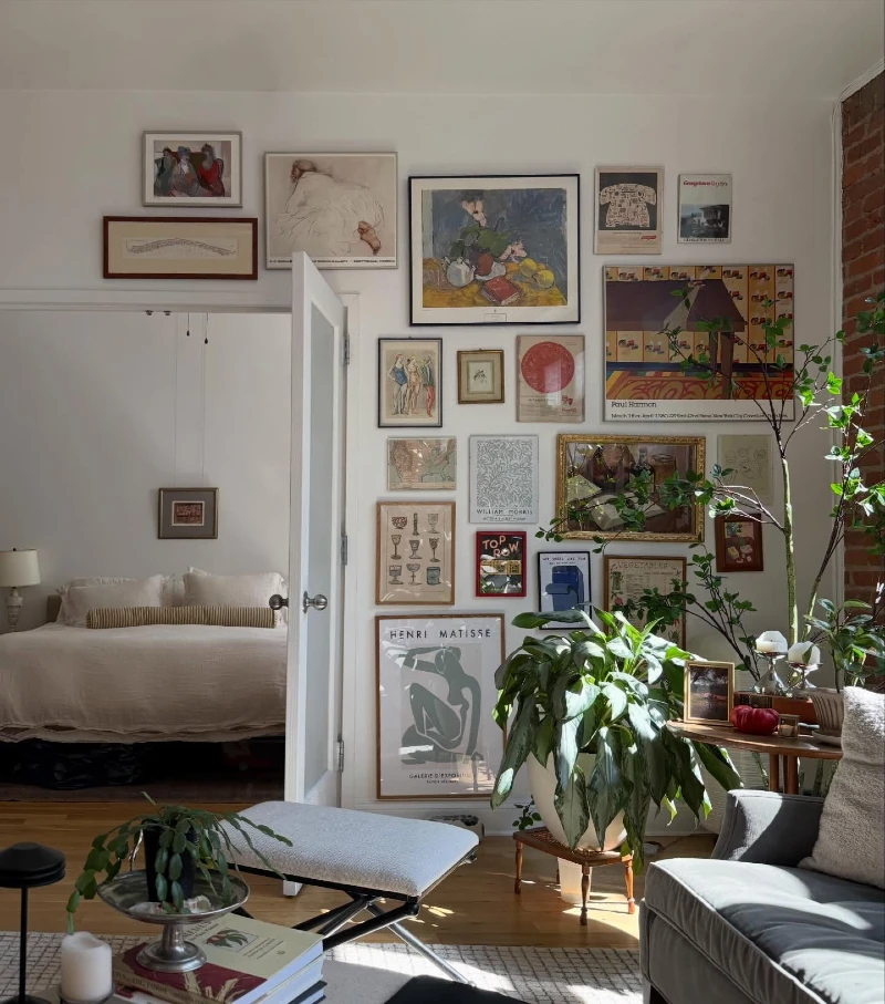 4. Eclectic Salon Wall Above Doorway with Layered Vintage Frames and Indoor Plants