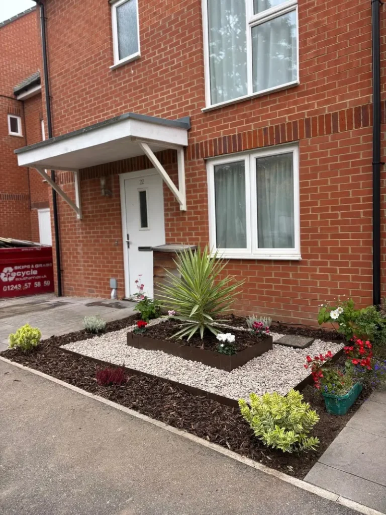 4. White Pebble Square with Spiky Yucca, Dark Mulch, and Bright Border Flowers
