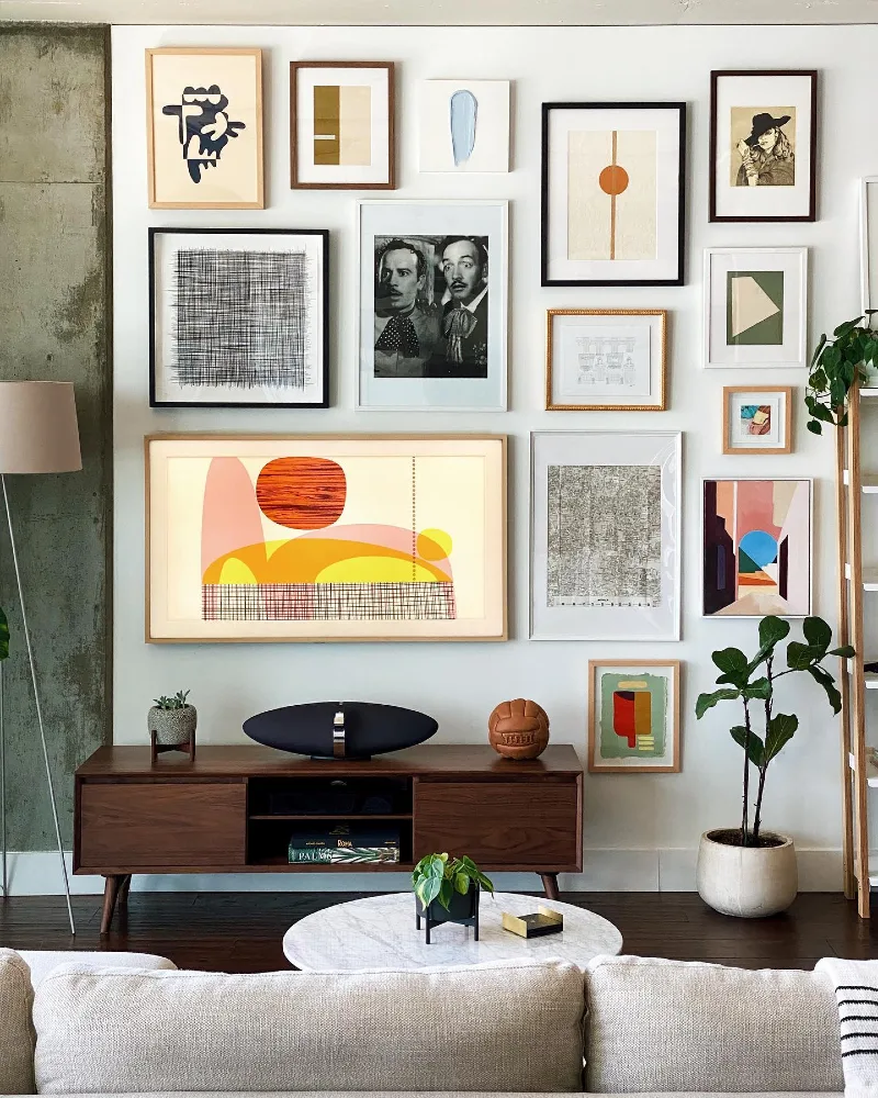 5. Bold Abstract Gallery Wall with Mixed Frames Above Mid-Century Media Console