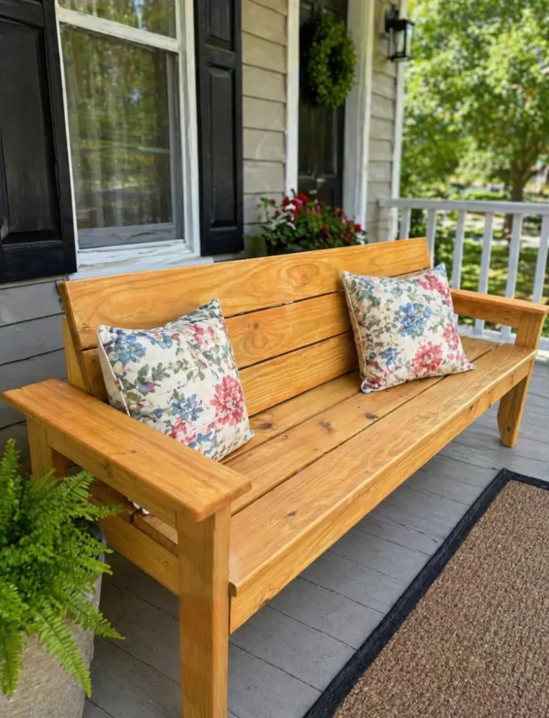 5. Golden Plank Porch Bench with Floral Pillows and Wide Armrests