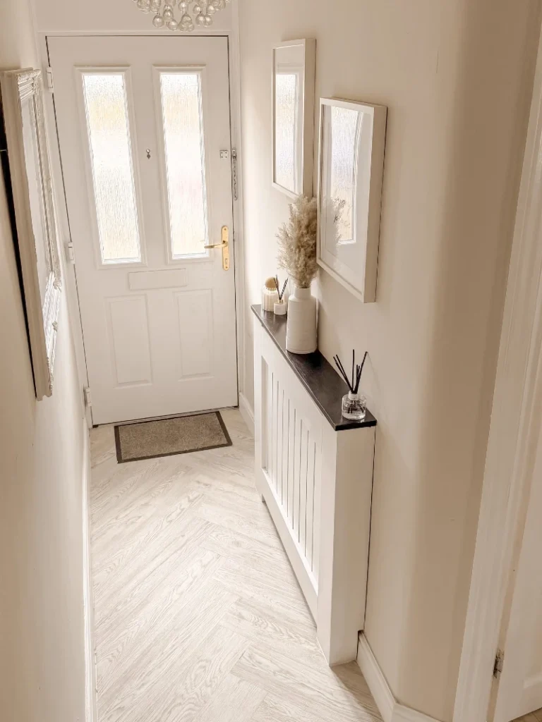 5. Pale Herringbone Entry Floor with Cream Walls and Slim Console Styling