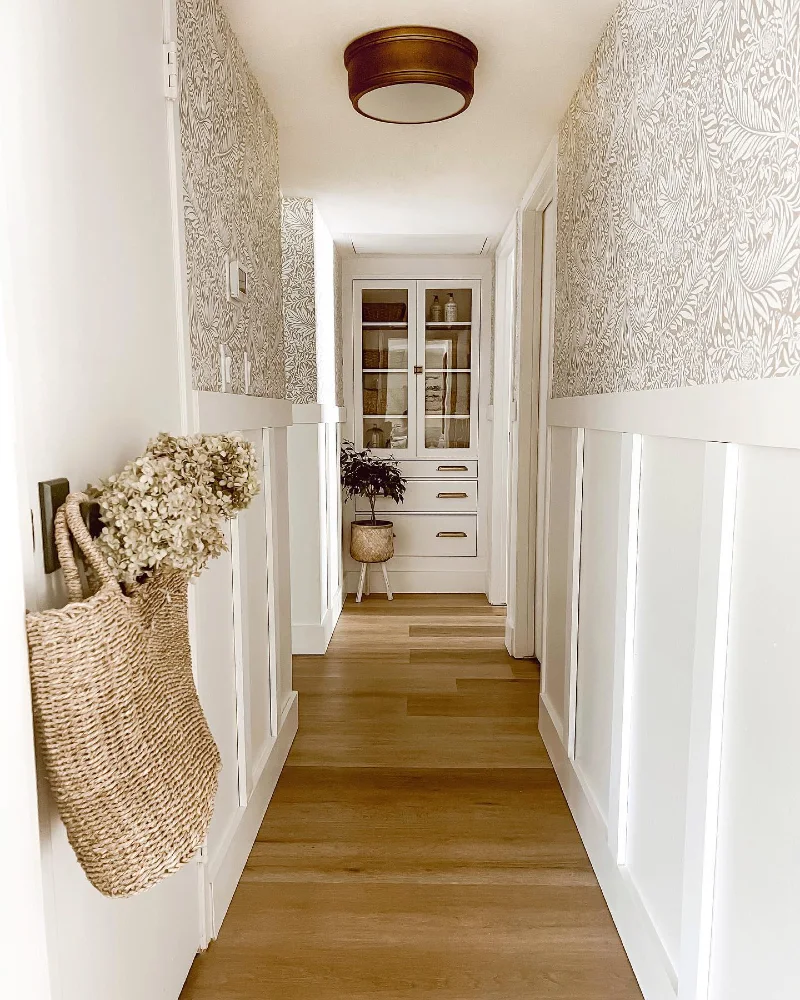 5. Soft Beige Botanical Hallway with Wainscoting and Warm Wood Floors