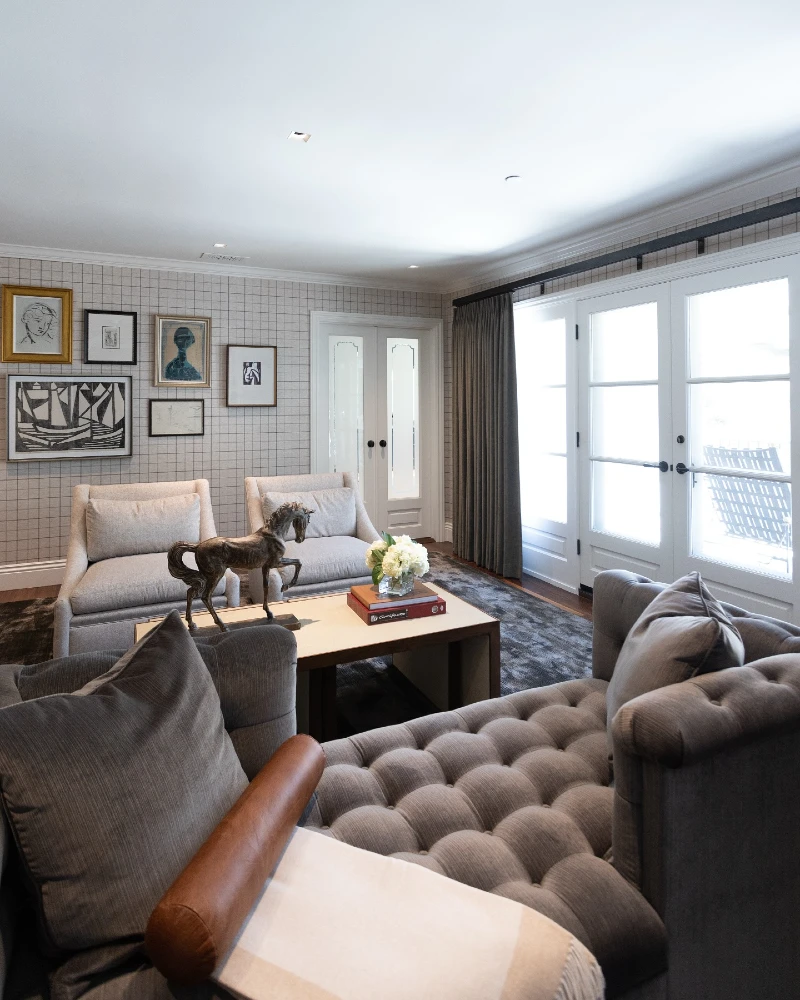 5. Tufted Gray Seating with Grid Wallpaper and Bronze Horse Sculpture