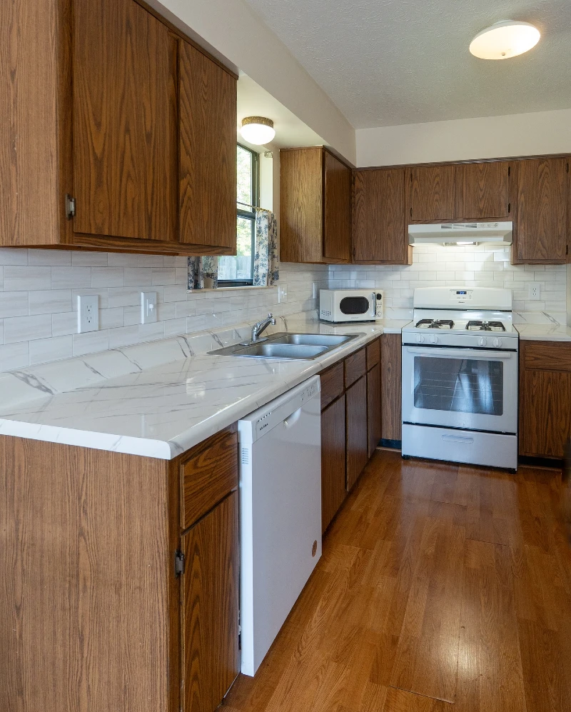 5. Warm Wood Cabinets with Marble Look Counter and Classic Rental Layout