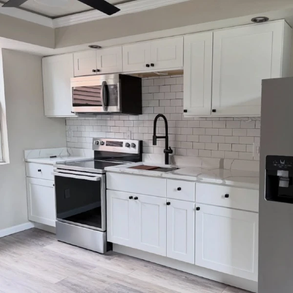 6. Bright White Shaker Cabinets with Subway Tile and Matte Black Faucet
