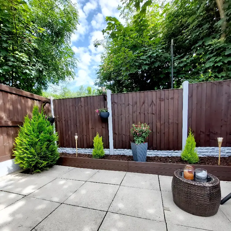 6. Brown Fence with White Posts, Evergreen Planters, and Solar Stake Lights