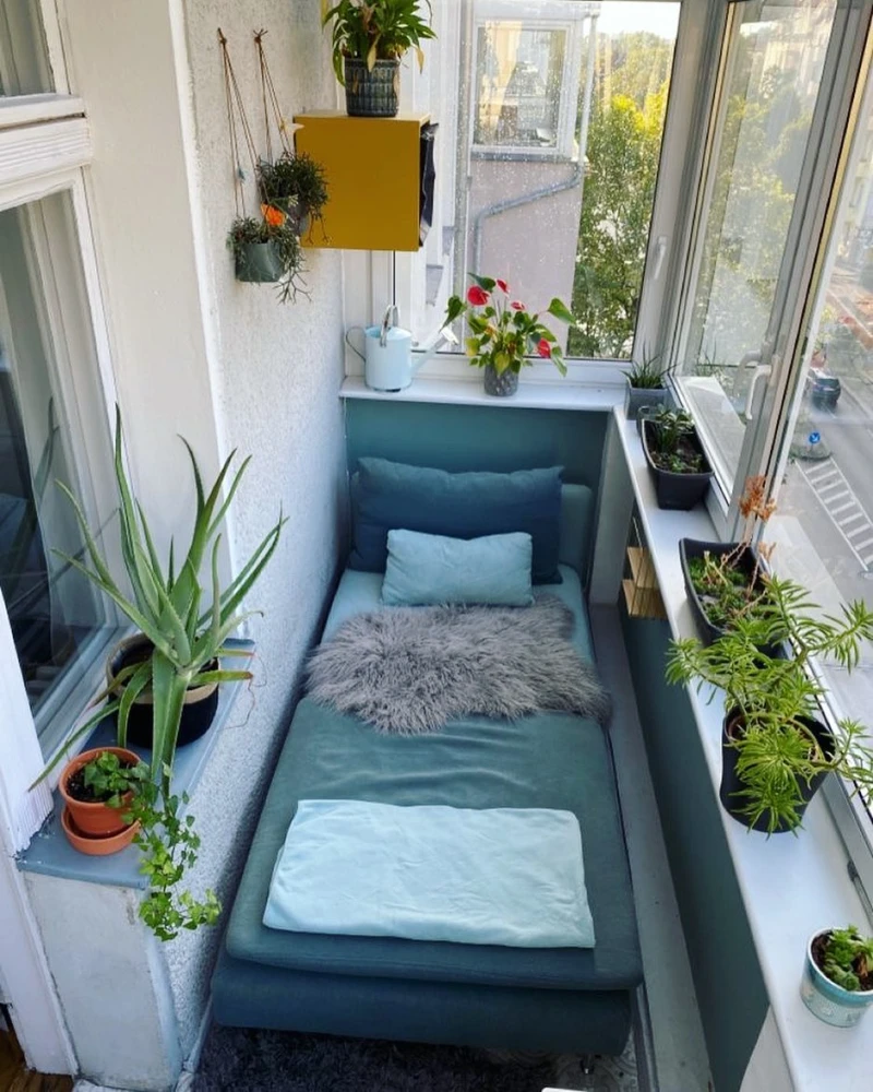 7. Glass Enclosed Balcony Daybed with Teal Cushions
