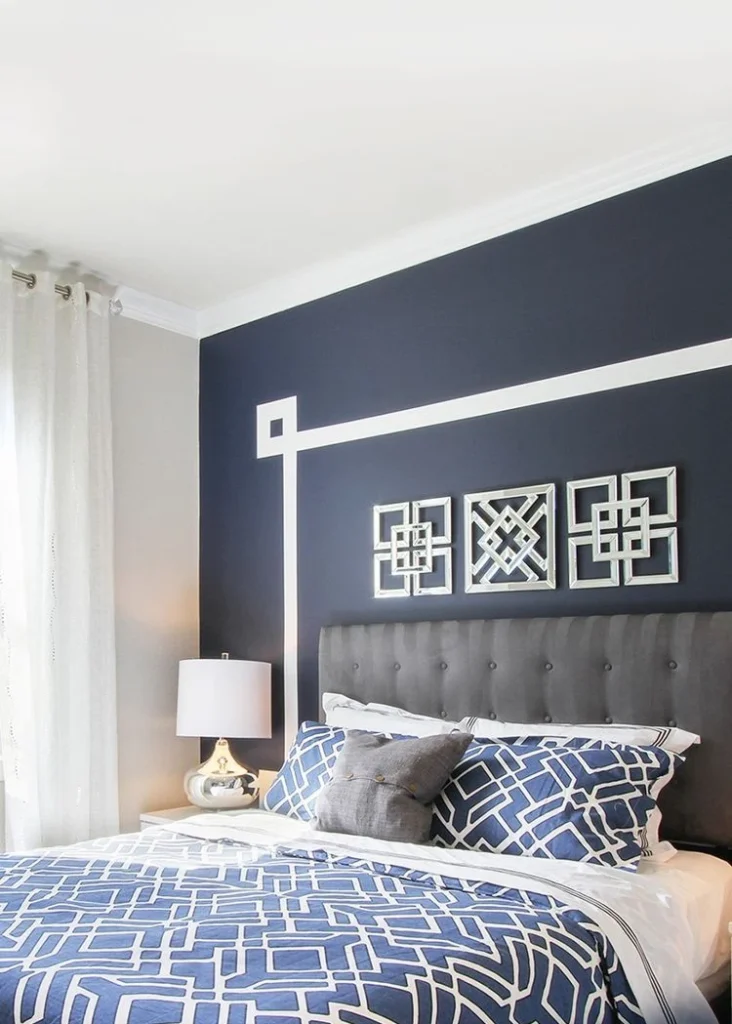 7. Navy Bedroom Accent Wall with White Line Geometry and Framed Art Grid