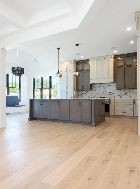 7. Pale Wide Plank Kitchen Floor with Two Tone Cabinets and Marble Vein Backsplash