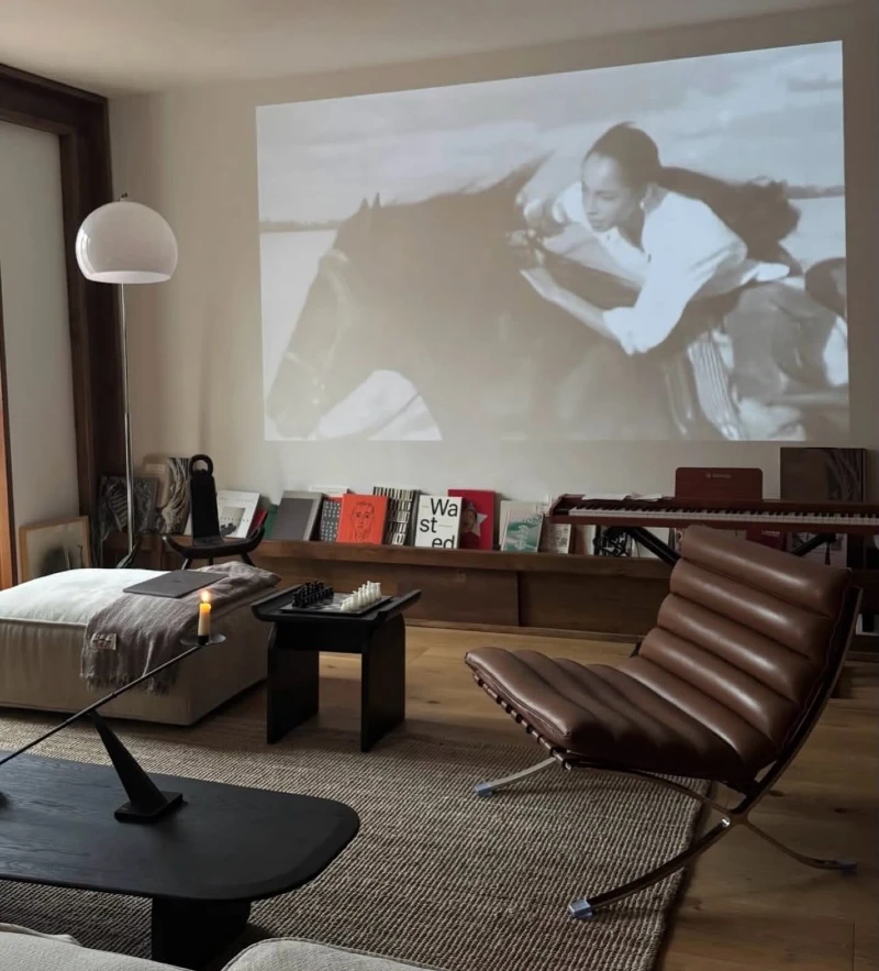 7. Wall Projector Lounge with Brown Ribbed Chair, Keyboard Console, and Candle Table