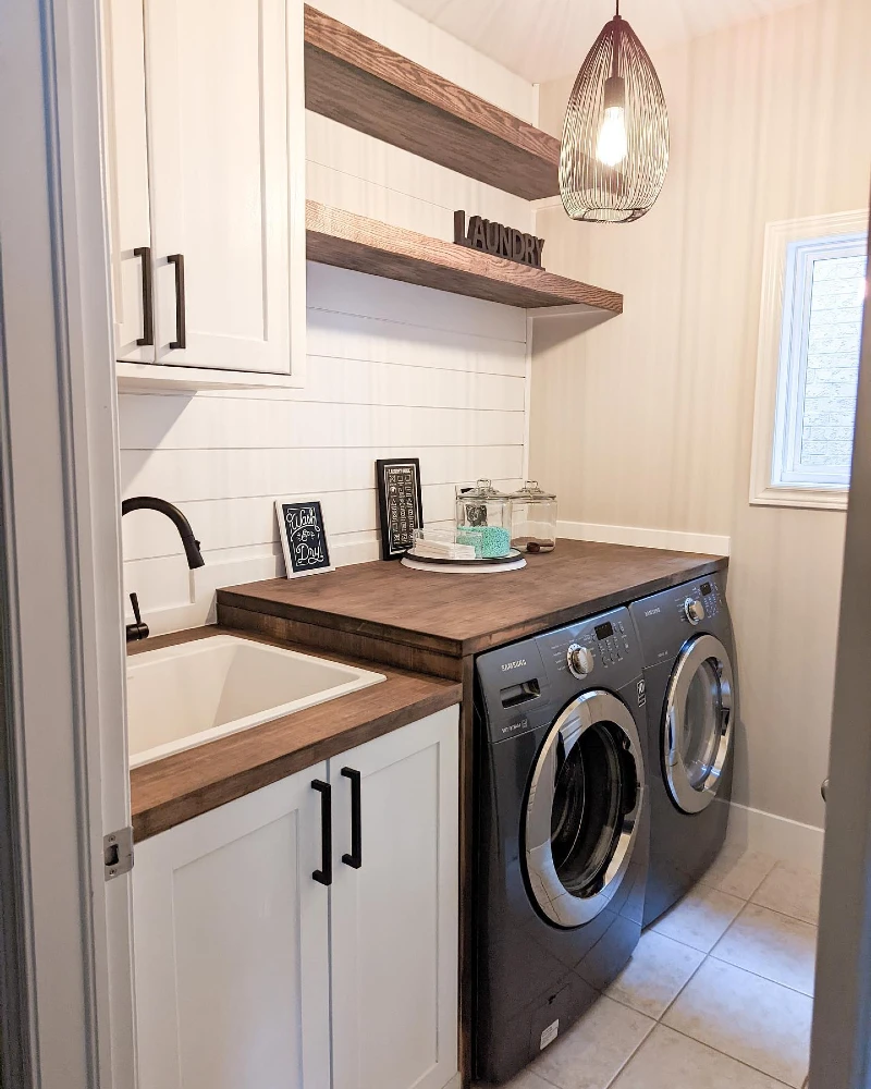 7. White Shaker Laundry Room with Wood Counters, Black Machines, and Wire Pendant Light