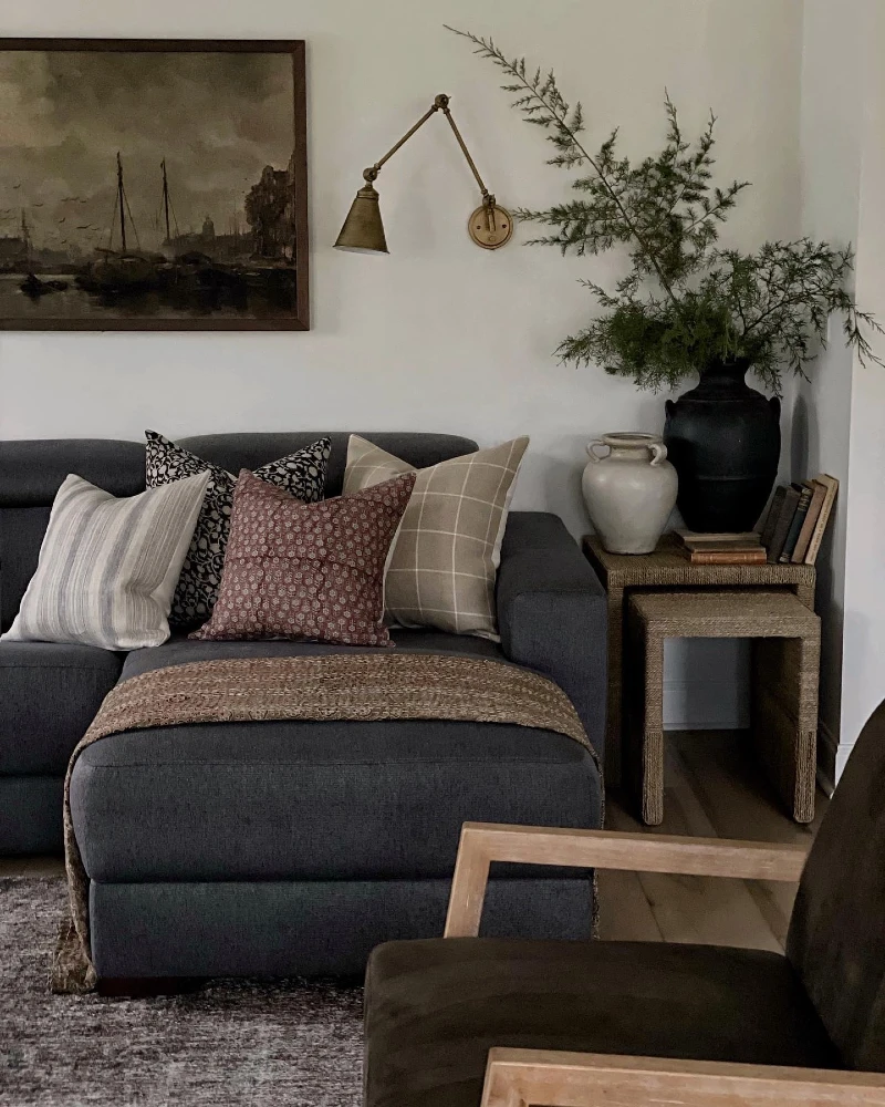 8. Charcoal Chaise Sofa with Woven Side Tables, Vintage Art, and Dark Wood Chair Frame