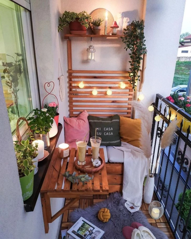 8. Pallet Wood Balcony Nook with Globe Lights, Plant Shelf, and Gray Faux Fur Rug