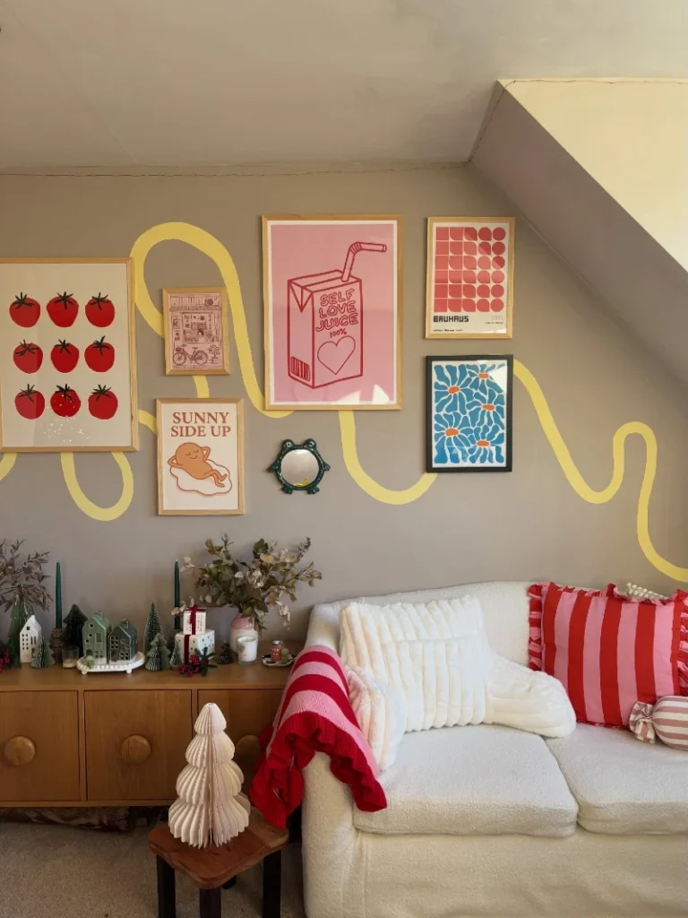 8. Playful Graphic Gallery Wall with Yellow Line Art Above Cream Sofa and Bold Cushions