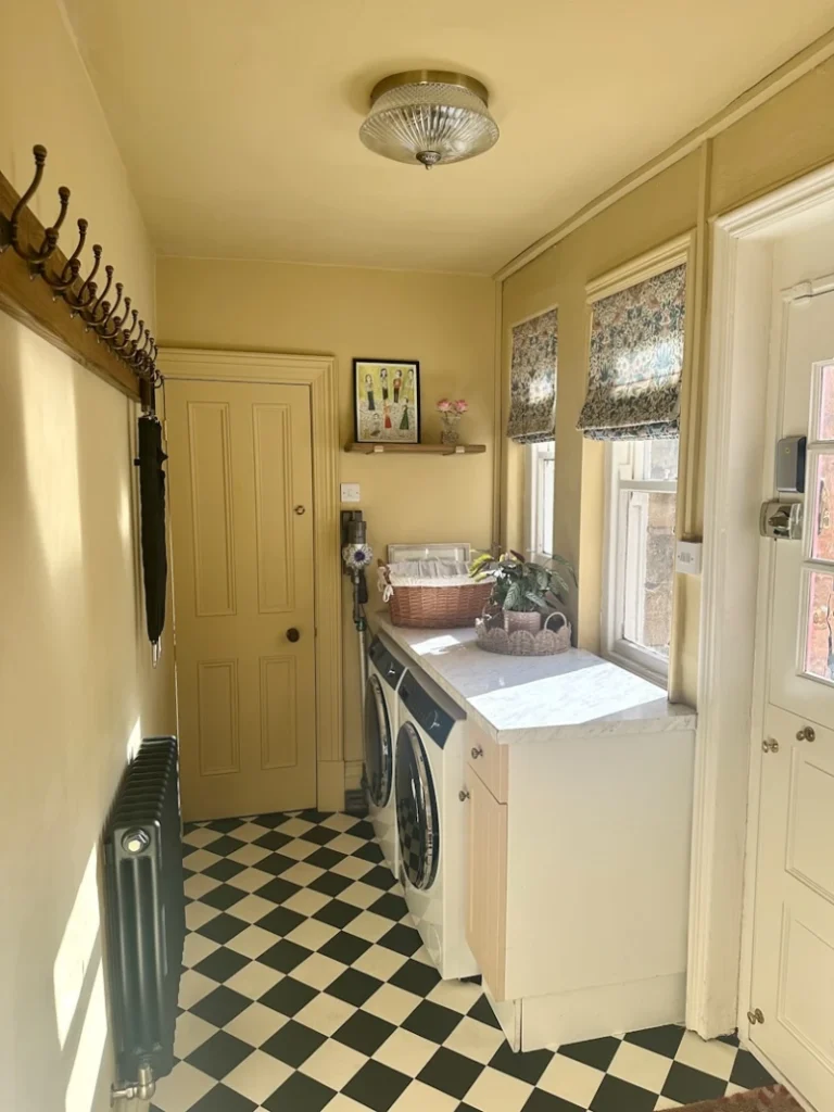 9. Butter Yellow Laundry Hall with Marble Counter, Checkerboard Floor, and Long Hook Rail