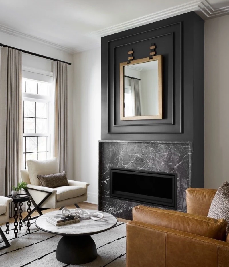 9. Charcoal Fireplace Wall with Brass Mirror, Marble Surround, and Cognac Leather Chair