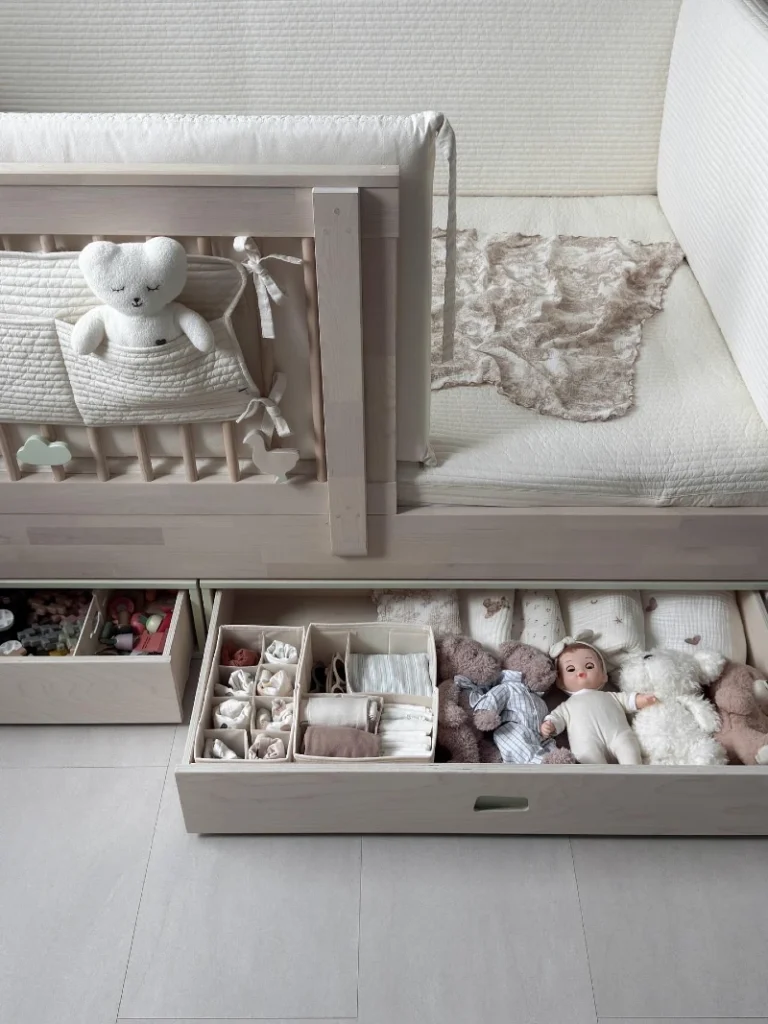 9. Pale Wood Toddler Bed with Pullout Drawers, Divided Clothes Trays, and Plush Toy Storage