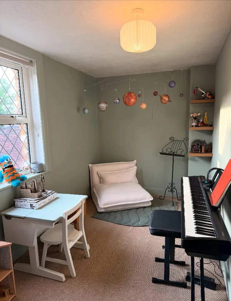 9. Sage Creative Corner with Floor Cushion, Solar System Mobile, and Piano Setup