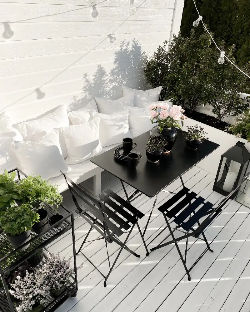 9. White Deck Balcony with Black Bistro Set, Pillow Bench, and Pink Peony Centerpiece