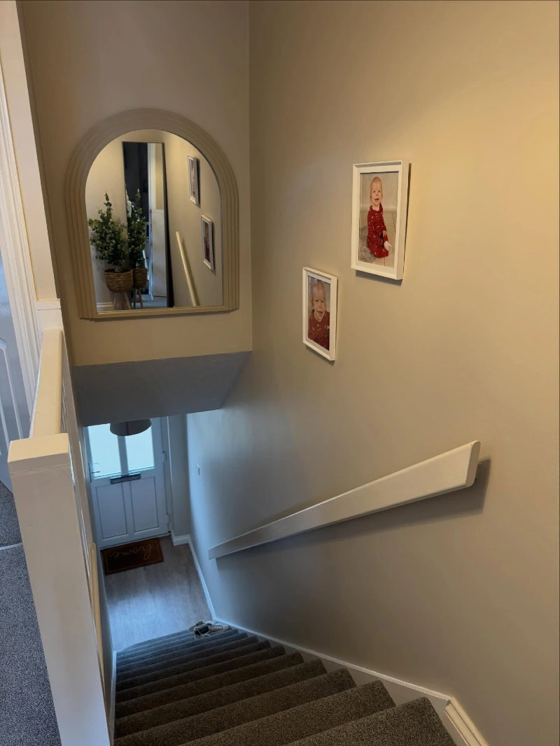 Arched Greige Mirror with Stair-Stepped White Picture Frames