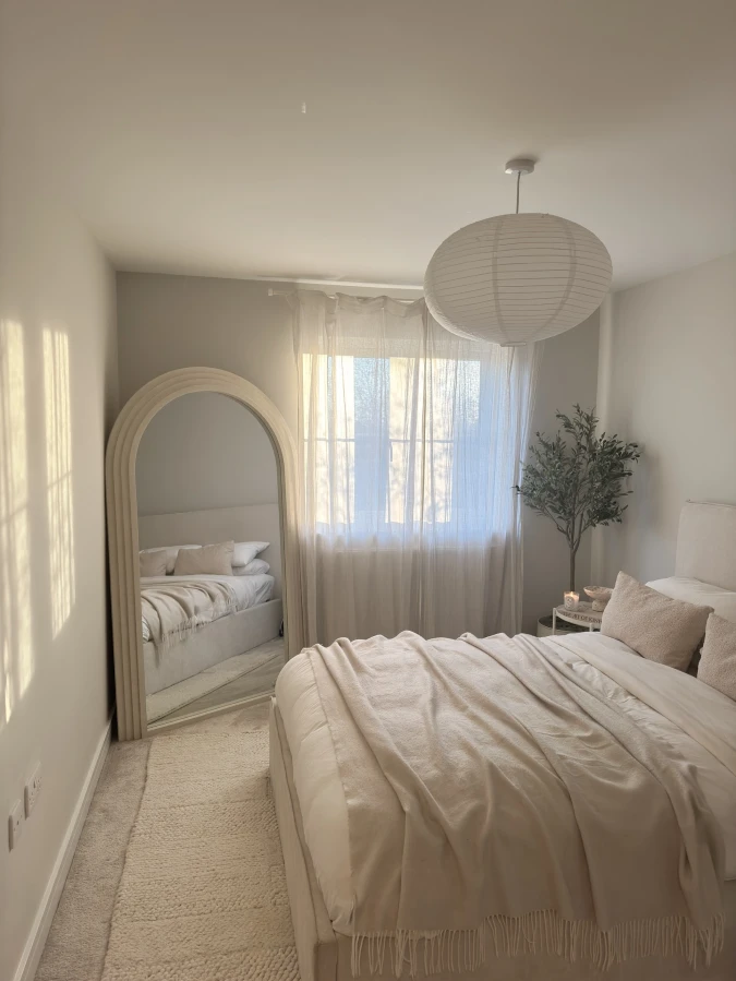 Arched Mirror Bedroom with Gauzy Curtains and Cream Layers