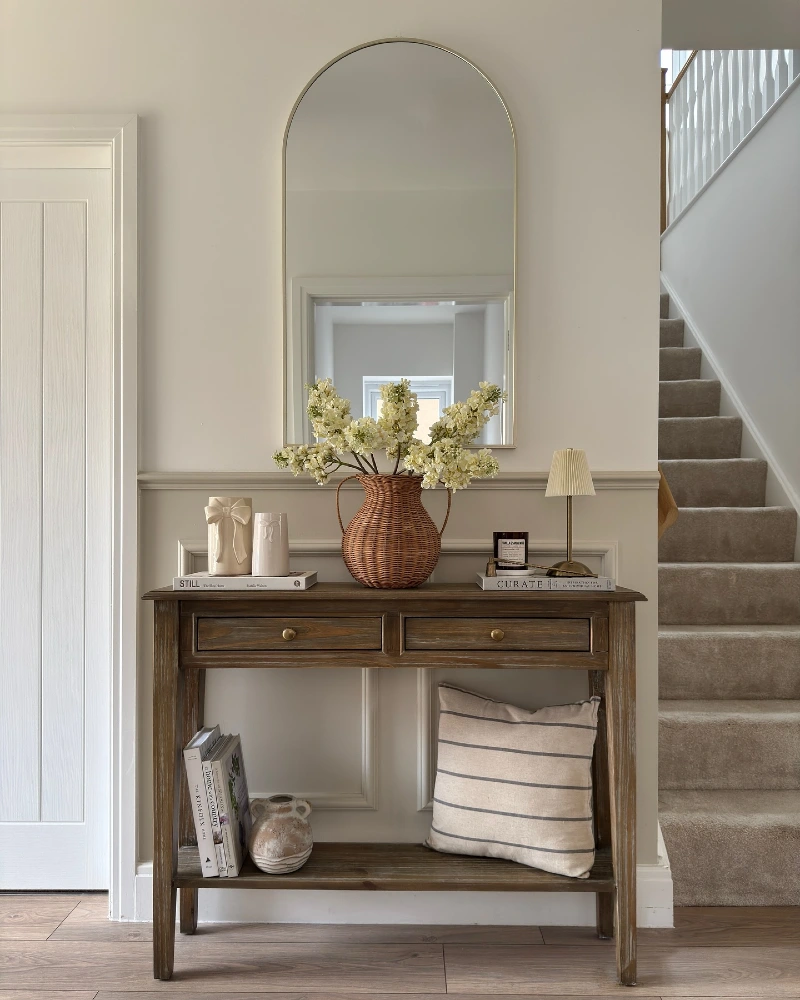 Arched Mirror Console with Wicker Vase, Cream Blooms, and Stairway Styling