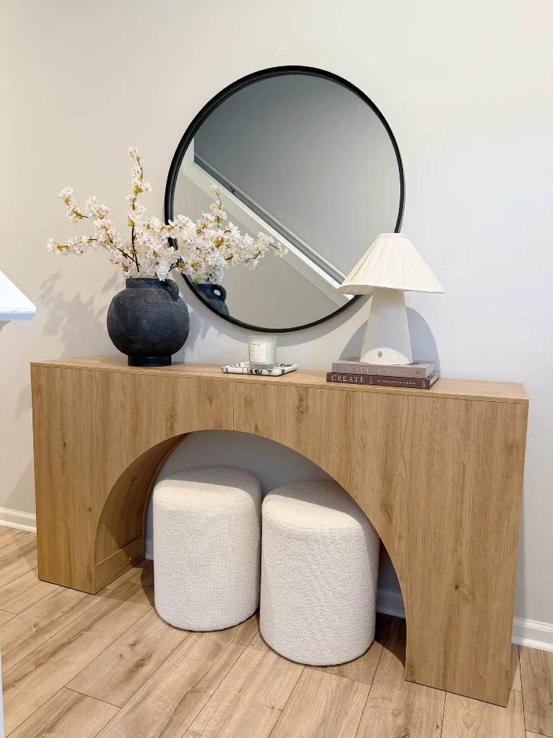 Arched Wood Console with Black Round Mirror, Blossom Vase, and BouclΓ© Stools