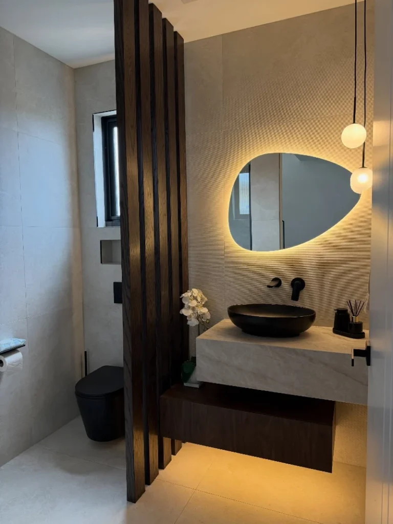 Backlit Pebble Mirror with Black Vessel Sink