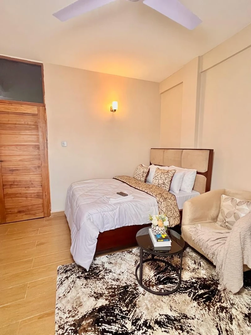 Beige Apartment Bedroom with Sofa Seating and Round Coffee Table
