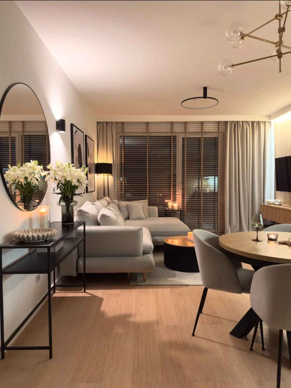 Beige Sectional Living and Dining Space with Sheer Curtains and Black Console Table