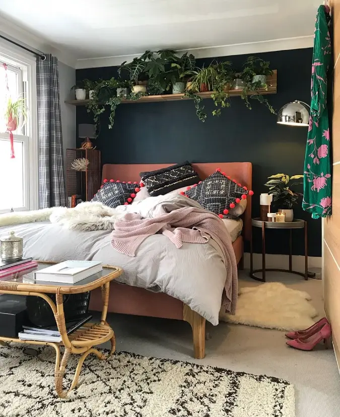 Black Accent Wall with Plant Shelf and Blush Bed Frame