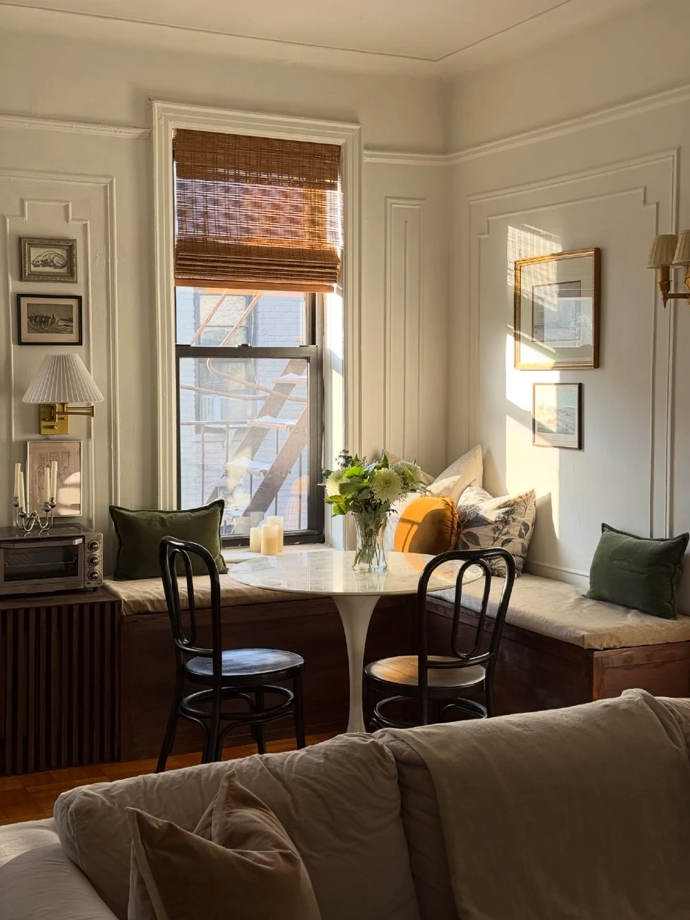 Built-In Window Banquette Dining Nook with Round Pedestal Table and Warm Wood Accents