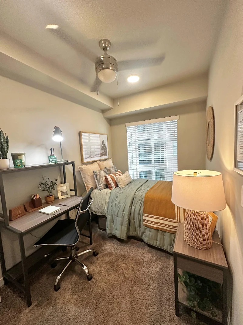 Compact Bedroom with Dedicated Study Desk, Warm Neutral Layers and Ceiling Fan Lighting