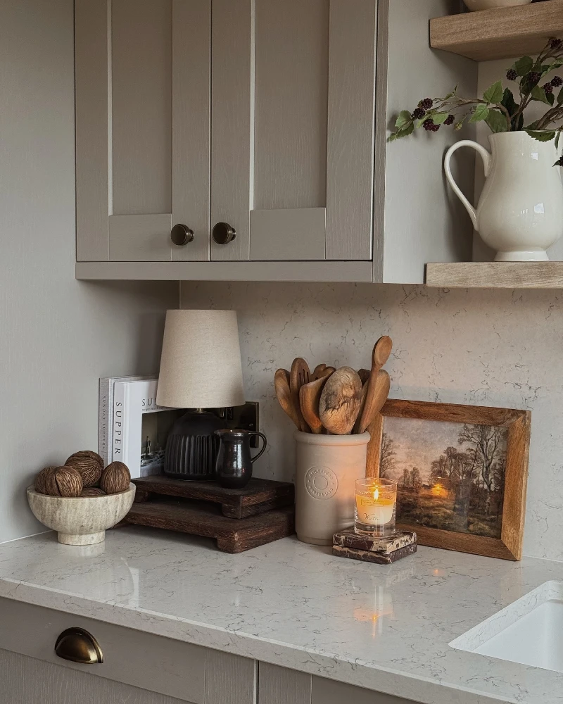 Countertop Lamp Corner with Wooden Utensils, Framed Art, and a Warm Candle Glow