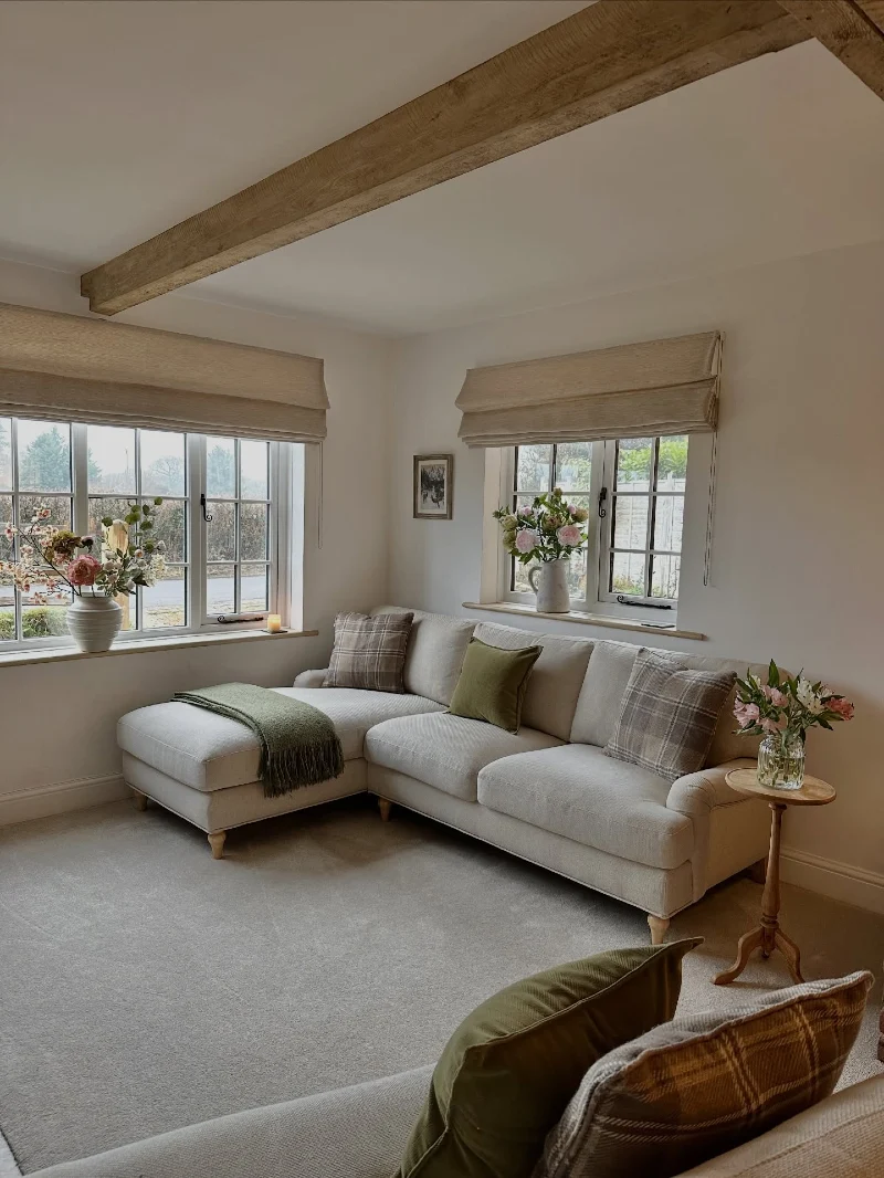 Cream Corner Sofa with Plaid Cushions and Oak Beam