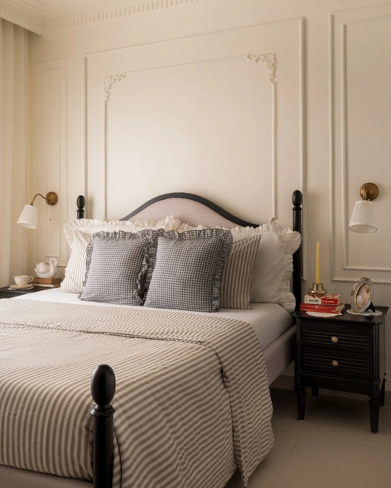 Cream Wall Molding Bedroom with Contrast Bedding and Classic Black Bed Posts
