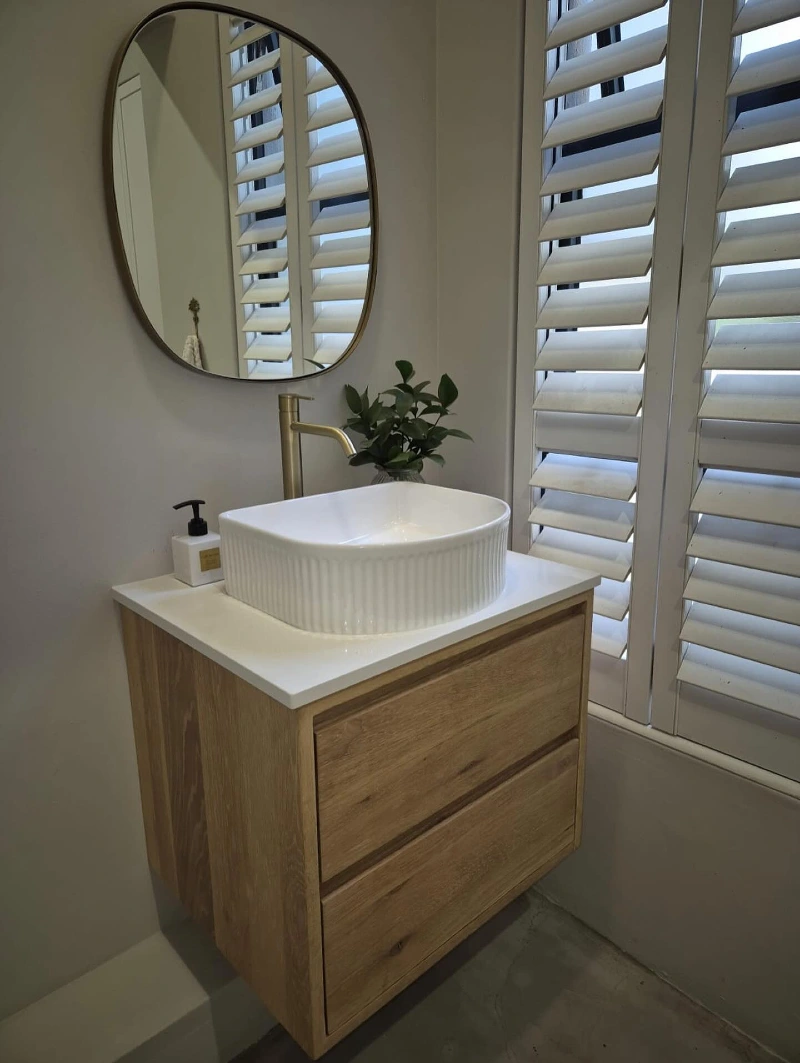 Floating Light Oak Vanity with Fluted White Vessel Sink and Asymmetric Gold Mirror