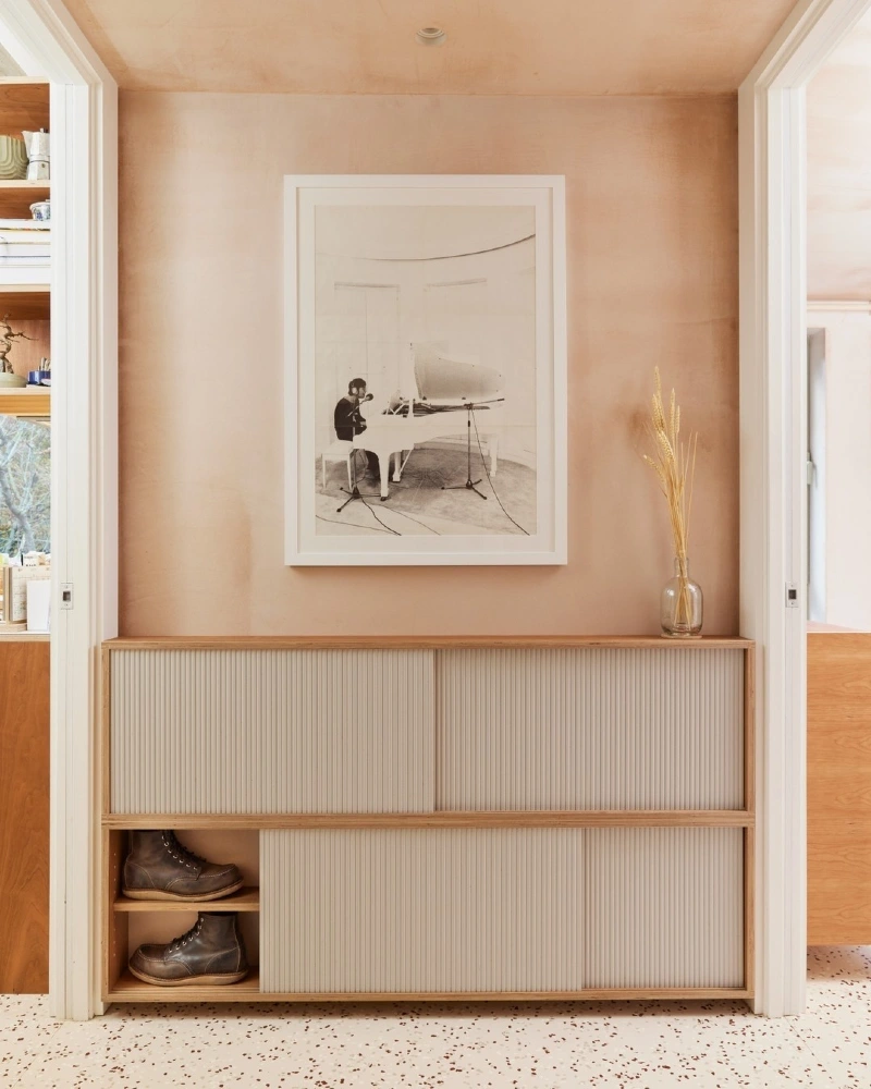 Fluted Sliding-Door Cream Credenza set Against Terracotta Plaster Walls