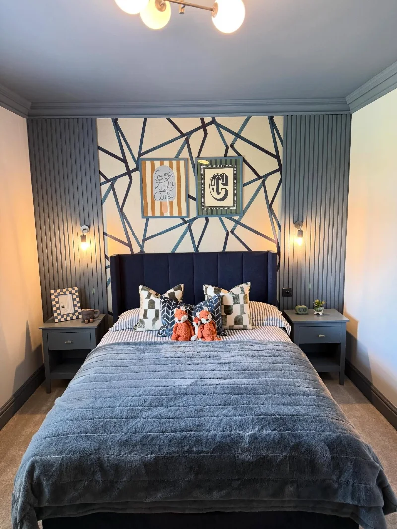 Geometric Accent Wall Bedroom with Soft Blue Bedding and Playful Twin Decor