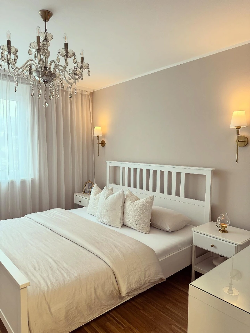 Glass Chandelier Over Crisp White Scandinavian Bedding