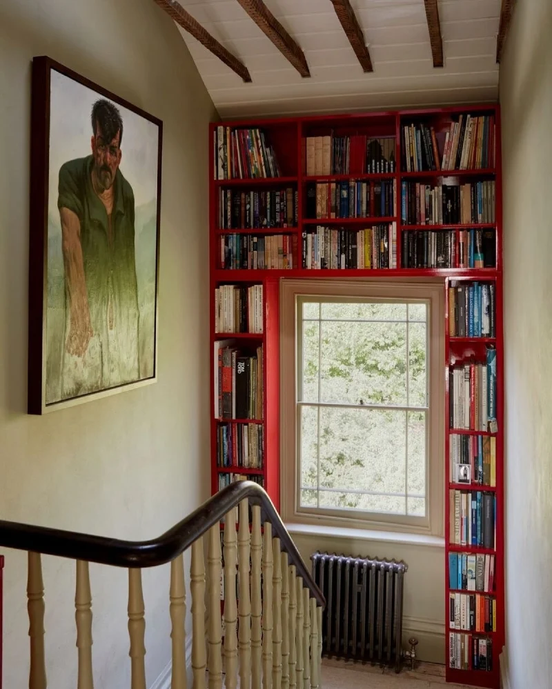 Glossy Crimson Built-in Bookshelves Framing a Centered Sash Window