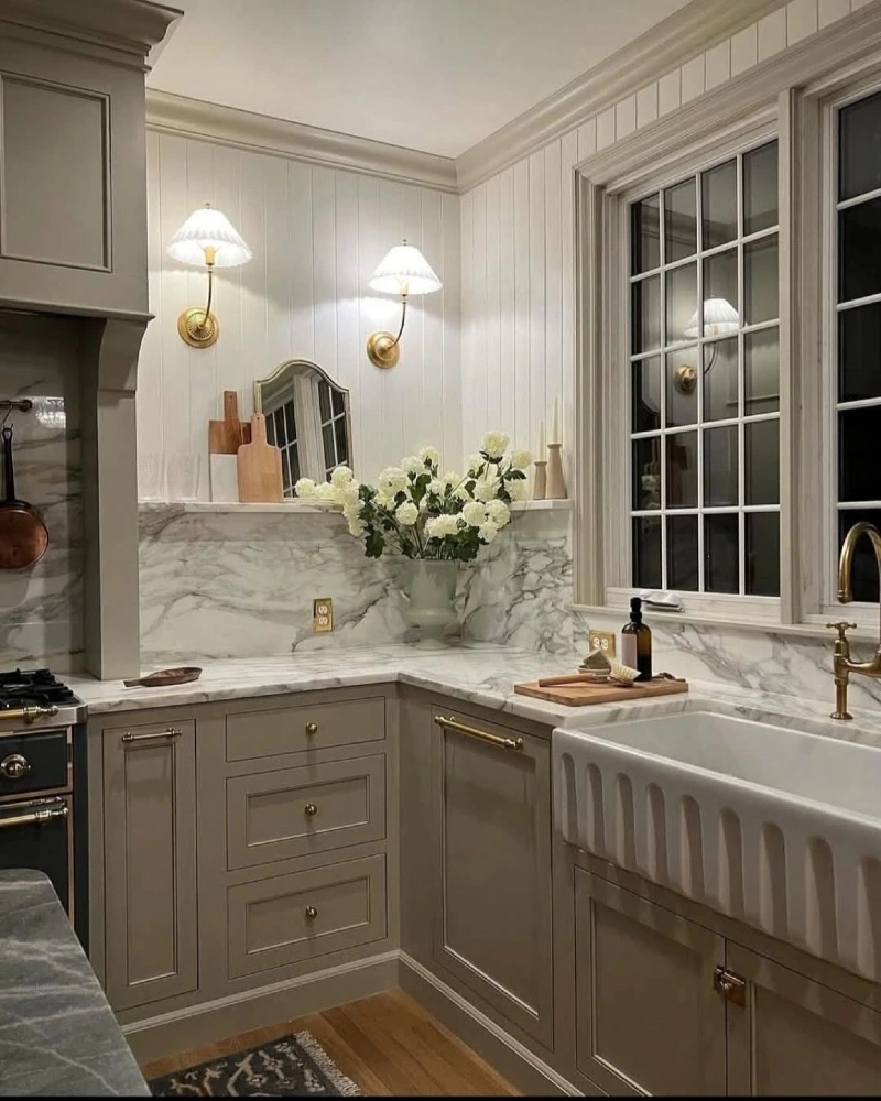 Marble Sink Corner with Fluted Farmhouse Sink, Brass Sconces, and White Florals