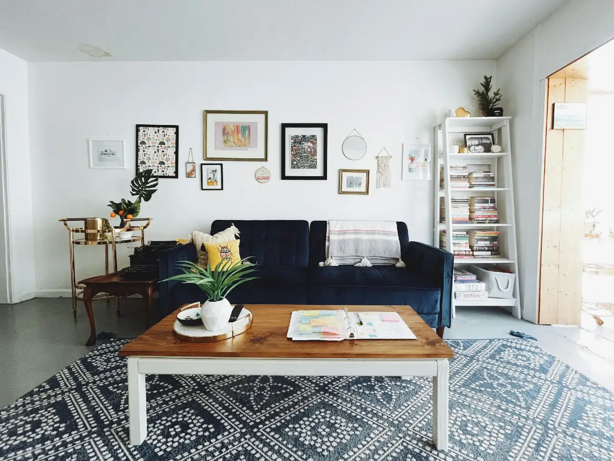 Navy Velvet Sofa with Eclectic Gallery Wall and Tall Bookcase