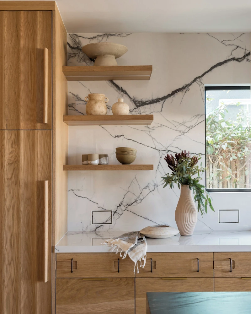 Oak Shelf Corner with Bold Marble Veining, Ribbed Vase, and Stone Bowls