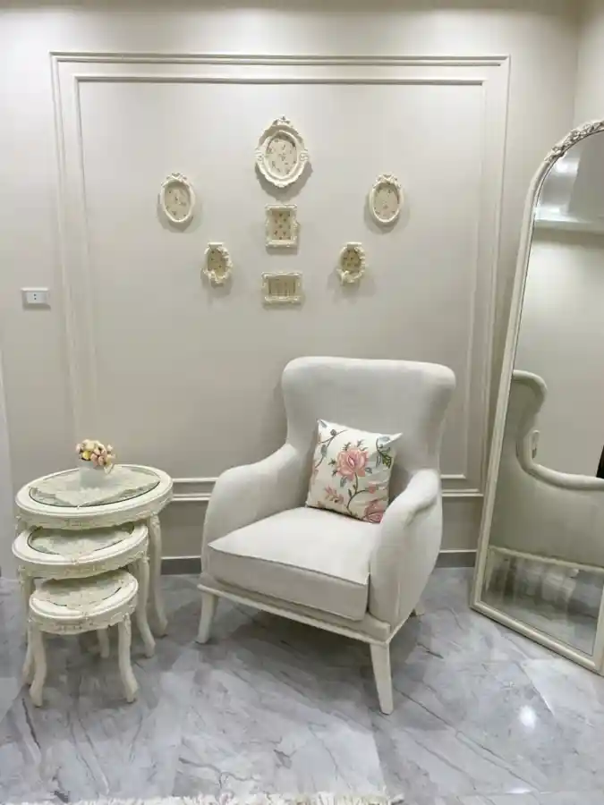 Off-White Wingback Chair with Vintage Ornate Wall Frames