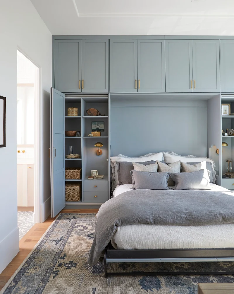 Powder Blue Storage Wall with Hidden Bifold Bookcases and Brass Dome Sconces